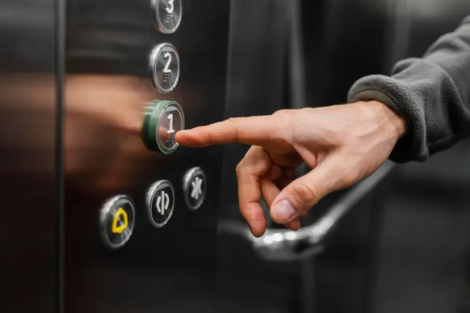 A resident pressing the call button for a communal lift