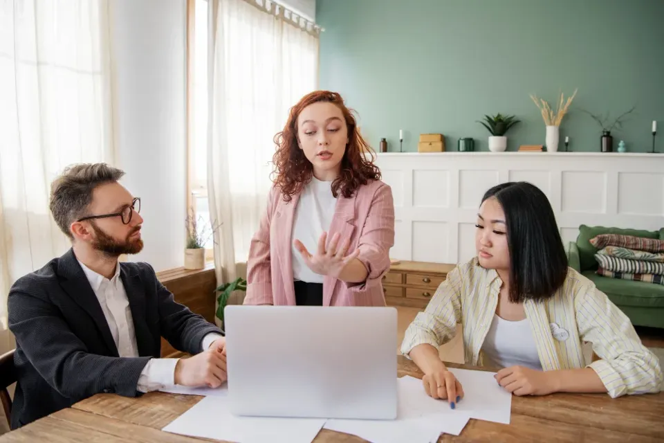 Three colleagues working through a question together at a laptop