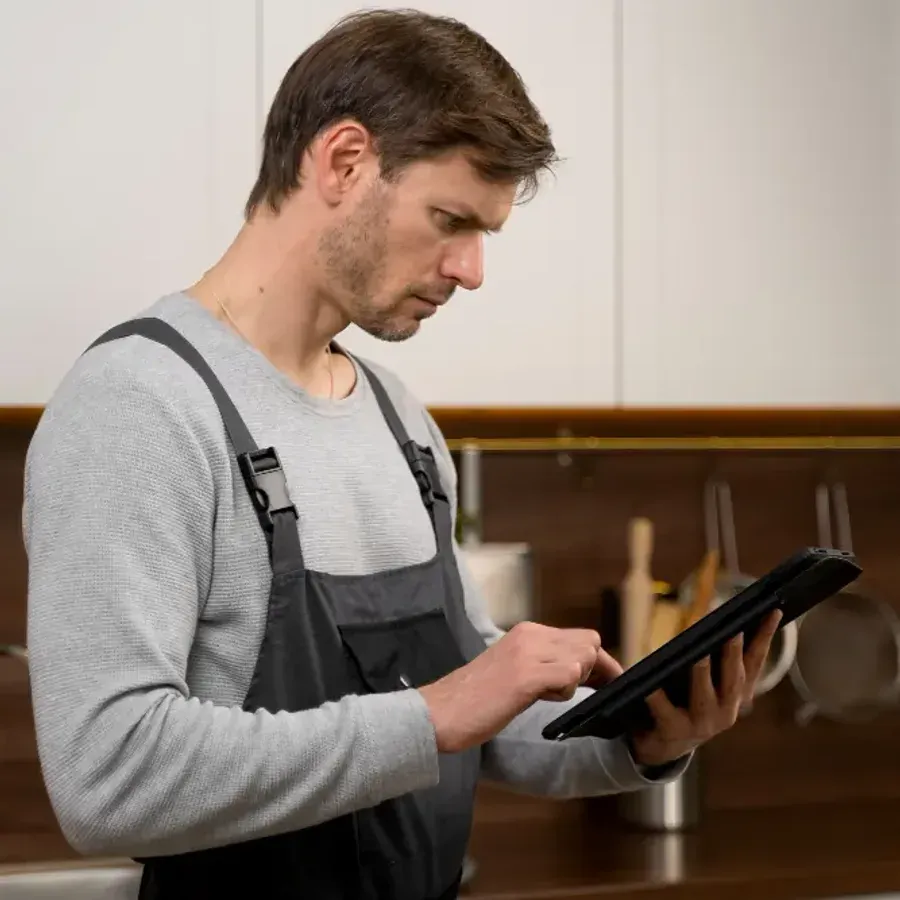 A contractor updating a job on a tablet in a property