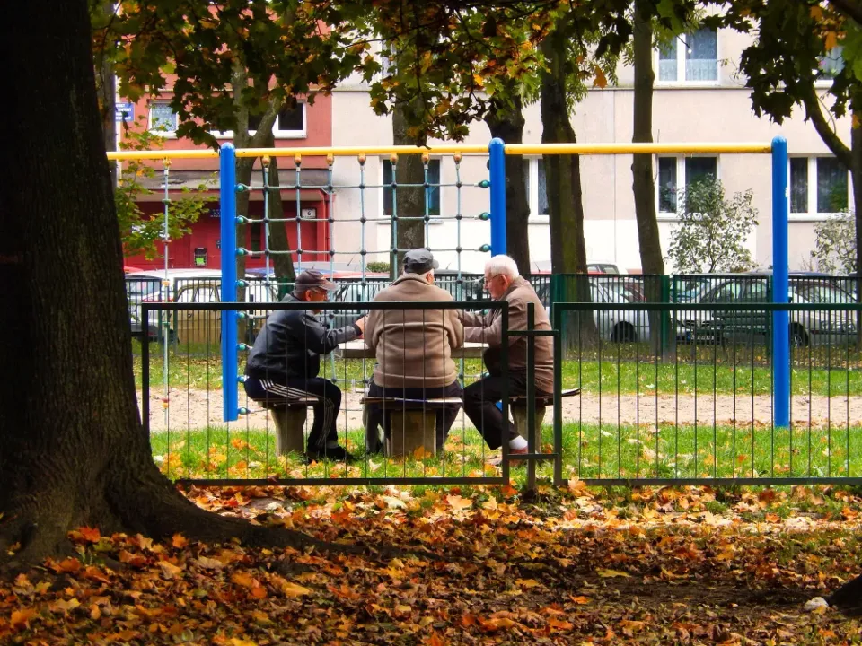 A resident sitting on a bench on an estate in autumn