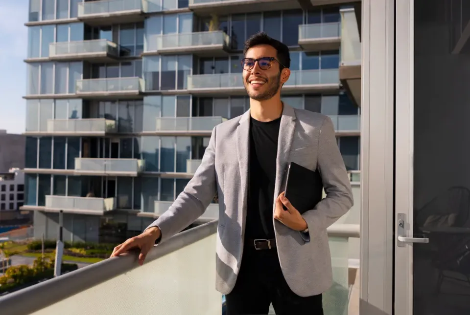 A property manager outside a modern apartment block