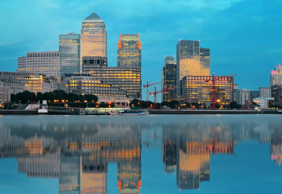 The London skyline at dusk, reflected in the water