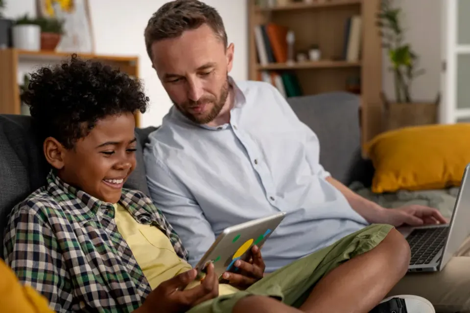 A parent and child at home, using a tablet together